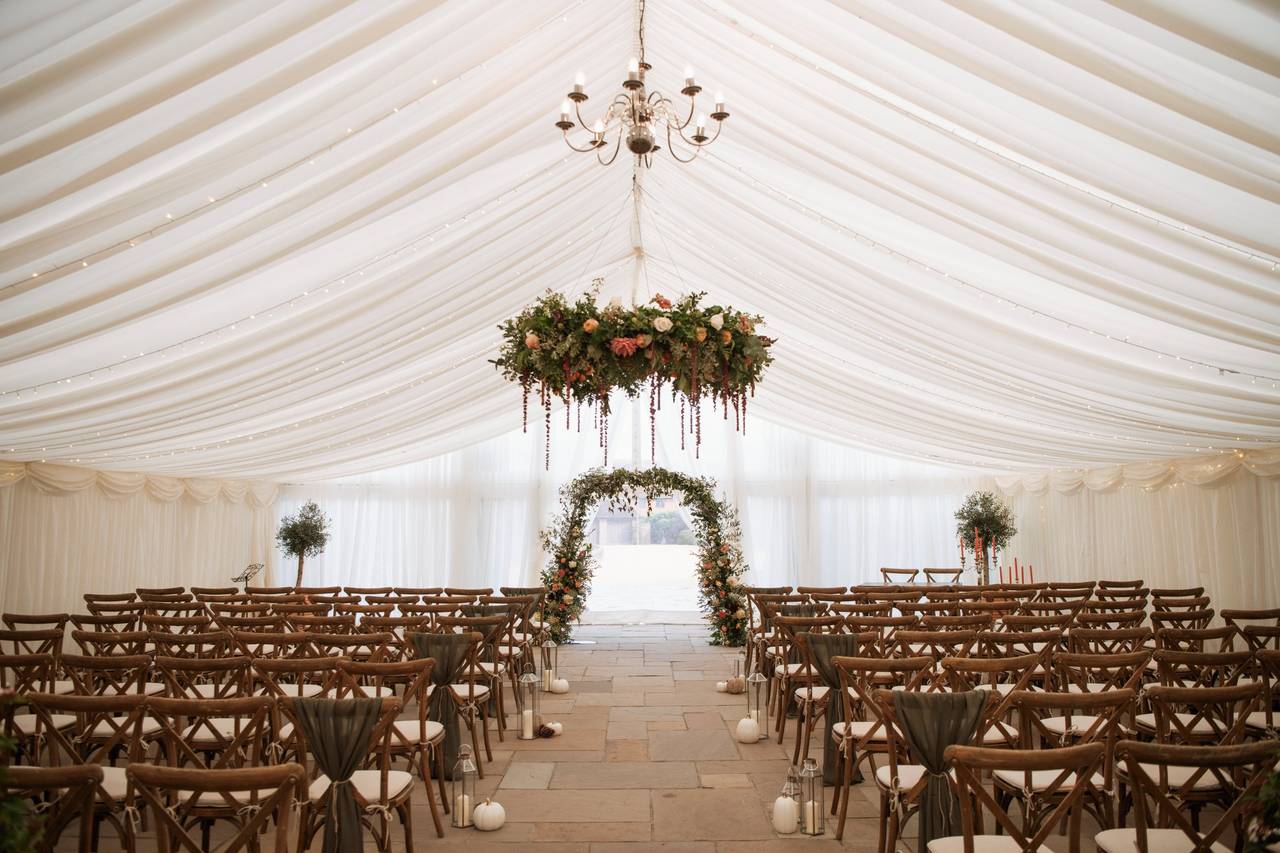 چیدمان مراسم عروسی با دکور گل و صندلی‌های چوبی